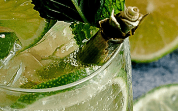 A mixed drink with ice, limes, and leafy greens | Dockside Cannabis