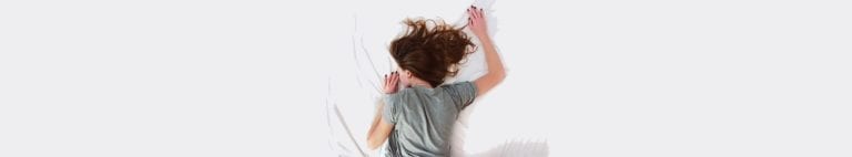 Woman sleeping on white sheets | Dockside Cannabis