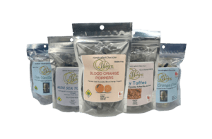 Group shot of the Wave Edibles chocolates. They're contained in silver plastic bags.